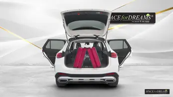Giant trunk volume of the Mercedes GLC utilized for free camping with a custom-fit car mattress in Magic Rosé.